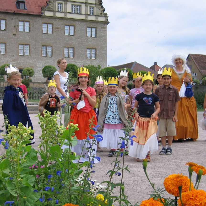 Schloss und Schlossgarten Weikersheim, verkleidete Besucherinnen und Besucher im Garten